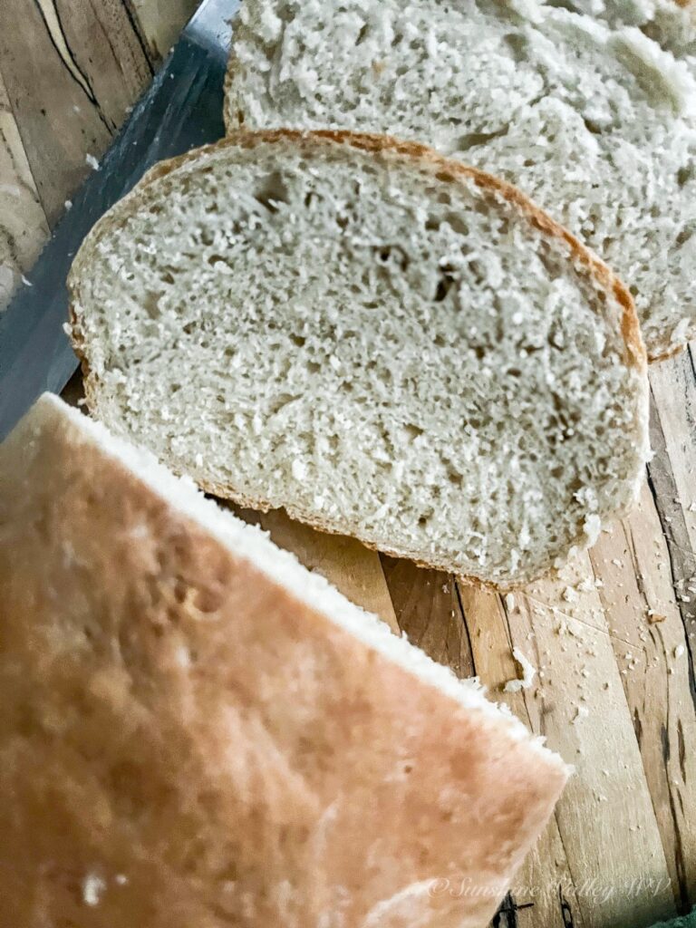 How to Make Simple 4-Ingredient Bread Recipe (No Fuss, No Starter) 5 simple 4-ingredient bread recipe sliced on a wooden cutting board.